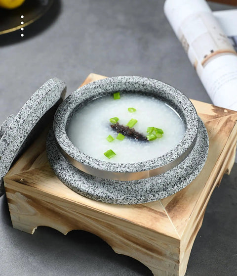 Dolsot Style Granite Stone Bowl With Lid 14 Cm on wooden holder filled with rice porridge and garnished, ideal for hot dishes