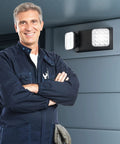 Technician with Black LED Exit Sign With Emergency Lights And Battery Backup 6 Pack Adjustable Two LED Heads mounted on wall