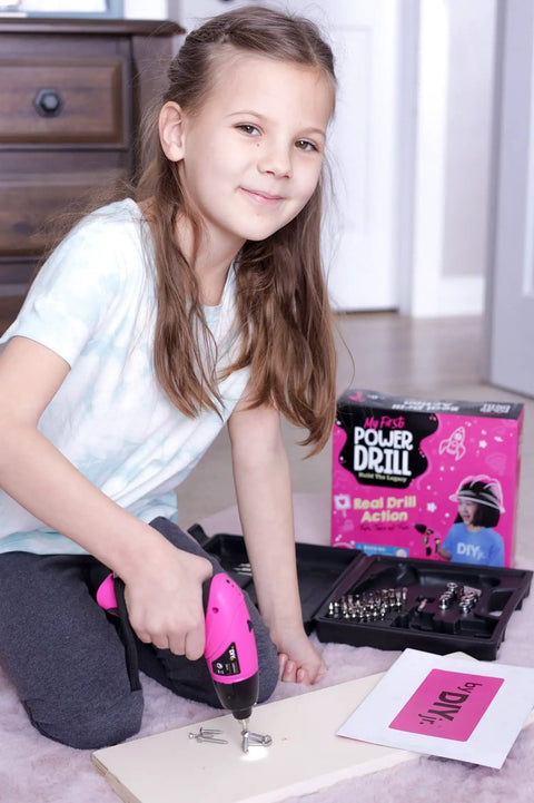 Girl using Girls Power Drill Set With Realistic Drilling Action 60 Piece Tool Kit Rechargeable Cordless Pink Drill With LED Light Learning And Building Construction Kit For Kids Includes Carrying Case And Charger