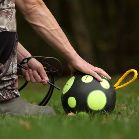 Person holding Ultra Portable 9 Inch Sand Filled Archery Target With Carry Handle For On The Go Practice Self Balancing Core