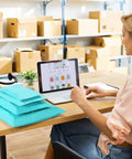 Woman organizing Teal Non Padded Poly Mailers 60 Pack Self Sealing Variety Pack With Five Sizes for e-commerce in an office space.