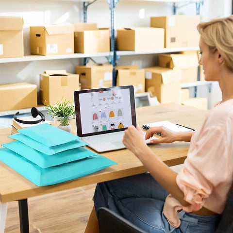 Woman organizing Teal Non Padded Poly Mailers 60 Pack Self Sealing Variety Pack With Five Sizes for e-commerce in an office space.