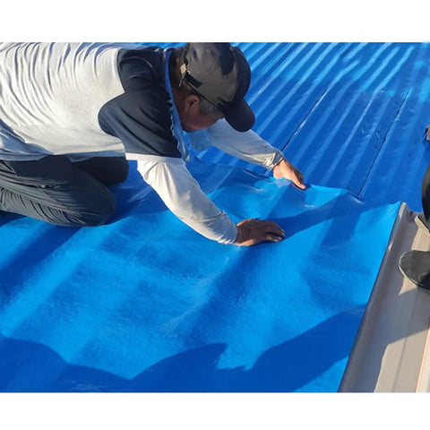 Worker installing Heavy Duty Waterproof Roofing Felt Tape Self Adhesive Asphalt Shingle Repair Roll on a roof surface.