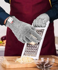 Person using 4 Pack Cut Resistant Gloves Level 5 Protection For Kitchen Prep And Food Handling, Anti Cut Safety For Meat Cutting, Wood Carving, Mandolin Slicing And More, Sizes Medium And Large while grating cheese.