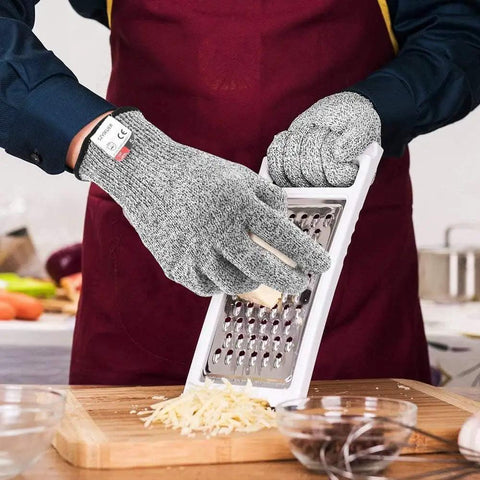 Person using 4 Pack Cut Resistant Gloves Level 5 Protection For Kitchen Prep And Food Handling, Anti Cut Safety For Meat Cutting, Wood Carving, Mandolin Slicing And More, Sizes Medium And Large while grating cheese.
