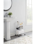 White three tier wheeled wire shelving cart with adjustable metal shelves in bathroom, featuring towels and toiletries, compact design.