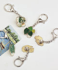 Front view of 6-pack enamel pin display keychains with green leaf plant pins on silver chains and lobster clasps.