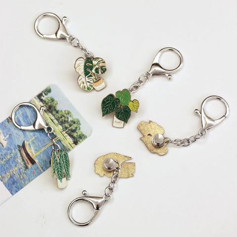 Front view of 6-pack enamel pin display keychains with green leaf plant pins on silver chains and lobster clasps.