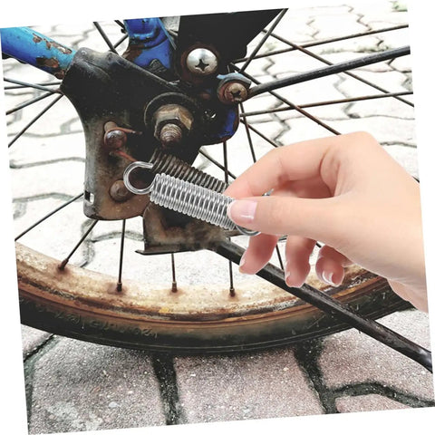 Grab This 8 Piece Small Compression Spring Kit With Hook Ends Perfect For Elevating Electric Vehicle Parking Stands And Securing Ladder Foot Supports To Keep Your Gear Rock Solid And Ready For Any Adventure. silver hook-end compression springs on a bike wheel