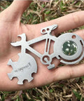 All In One Bicycle 10 In 1 Multitool Card For Everyday Carry And Keychain Access with wrenches, in a hand, outdoor background