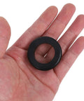 Black rubber cable grommet in hand from Six Piece Black Rubber Cable Grommet Kit For Wire Entry Holes That Improves Cable Routing And Protection With Durable Rubber Grommets For Safer Tidier Setups And Cable Damage Prevention.