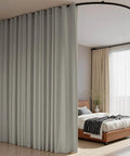 Flexible Ceiling Track Curtain System For L Shaped Or U Shaped Installations with blackout panels in light grey dividing bedroom.