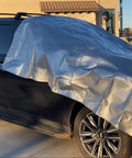 Heavy Duty Waterproof Tarp 10x12 Feet Ten Mil Poly Shelter For Roof And Outdoor Use covering a car, showing grommets and silver finish