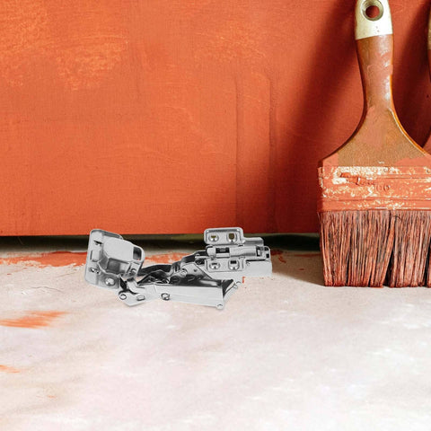 165 Degree Overlay Cabinet Hinges With Soft Close Damper 2 Pack metal hinges in front of painted wall and brushes
