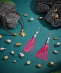 Check Out These 125 Pcs Tibetan Alloy Cord End Caps In 10 Cool Styles With Antique Silver And Golden Tones Perfect For Your Next DIY Jewelry Kit To Fix Necklace Bracelet Tips. Tibetan alloy cord end caps, silver and gold, with tassel earrings and bracelet on teal background.