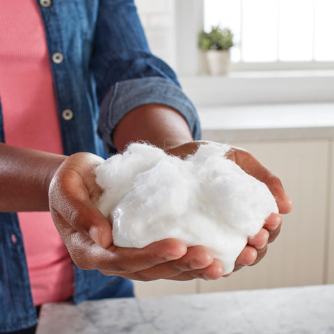 Hands holding crafted slime using Liquid School Glue That Bonds Paper, Wood, Fabric And More, Washable, Safe And Non Toxic.