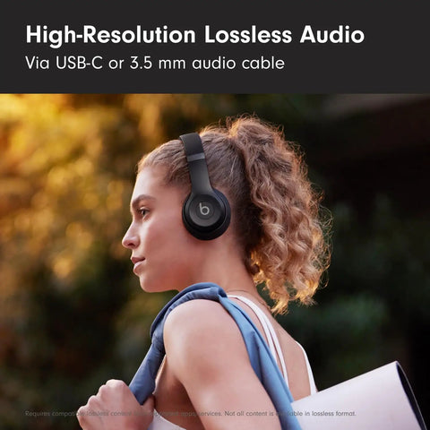 Solo 4 Wireless Bluetooth On-Ear Headphones Serving Serious Heat And 50-Hour Battery Life For Your Daily Ride Built With Ultra Lightweight Flex-Grip Cushions And Immersive Spatial Audio Technology In Matte Black on a woman wearing them outside.
