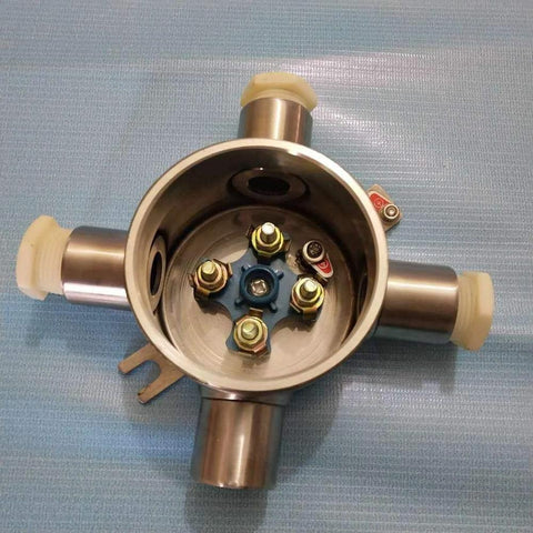 Front view of round stainless steel explosion-proof junction box with four conduit ports and blue terminal plate.
