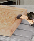 Close-up of Commercial Grade Aluminum Router Clamping Kit with T slot guides securing wooden stock on CNC milling surface.
