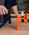 Person using Two Pack Heavy Duty Wood Gluing Pipe Clamp Fixtures For Three Quarter Inch Black Pipe Quick Adjust Pipe Clamps That Free Your Hands Great For Glue Ups Joints Repairs And Woodworking Projects secured on wooden table