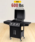 Black 3-burner outdoor grill with open lid and four caster wheels, max 600 lbs capacity displayed on hardwood floor