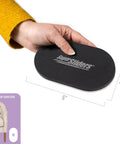 Hand holding a 3.5 x 6 inch oval furniture slider with logo, part of Three And One Half Inch By Six Inch Oval Felt Furniture Sliders Set Of Four For Hard Surfaces Anti Slip Moving Pads To Glide Beds Sofas Dressers And More Beige.
