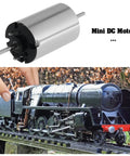Two Pack 12V DC Mini Motors 13477RPM Micro 1015D Motors For RC Cars DIY Projects Model Trains N Scale TT Scale H0 Gauge next to model train.