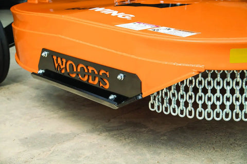 Close-up of rotary cutter base showing metal chains and 'Woods' label, for Replacement Driveline Universal Joint For Rotary Cutter Tiller And Finish Mower Fits 7144RD 9144 9180 9204 Series And Other Tractor Attachments OEM Quality For Heavy Duty Yard Work.