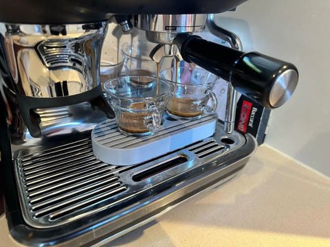 Level Up Your Counter Game With This Heavy Duty Cup Riser Platform designed to elevate espresso mugs by thirty millimeters on a drip pan.