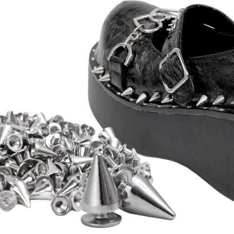 Black platform shoe with silver spikes; foreground shows assorted cone studs and rivets.