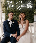 Custom Neon Sign Lit Up Name Sign LED Light For Wall Decor Bedroom Wedding Party Bar Shop With Adjustable Brightness And Five Flash Modes DC12V 60W Adapter US Plug 13ft Power Cord displayed above couple on porch swing