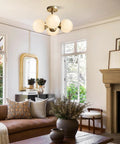 Antique Brass 4 Light Ceiling Light With Frosted Glass Globes, Mid Century Modern Chandelier in cozy living room setting