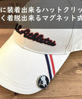 Swinging Bear Golf Ball Marker With Magnetic Hat Clip attached to a cap on a wooden table.