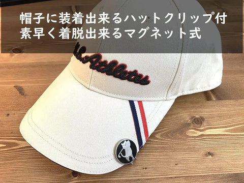 Swinging Bear Golf Ball Marker With Magnetic Hat Clip attached to a cap on a wooden table.