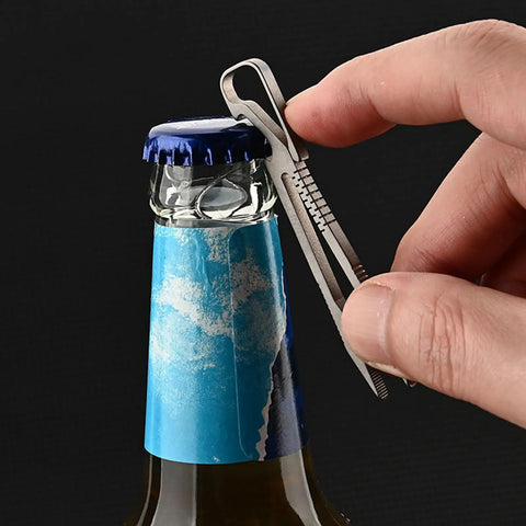 Alloy Pocket Tweezers For Camping And Hiking Gear, compact tool used as bottle opener, close-up on blue-capped bottle and hand