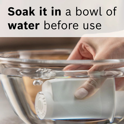 White water filter cartridge for espresso machines soaking in a clear glass bowl of water