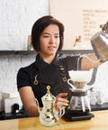 Barista using Stainless Steel Arabic Coffee Pot And Pour Over Teapot Set With Infuser Multiuse Coffee Kettle in cafe.