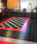 Installed interlocking garage floor tiles with diamond pattern, heavy-duty copolymer, black, in a garage workspace showcasing red accents.