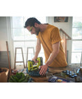 Man using Heavy Duty Cordless Electric Stapler Beast For Upholstery Carpet Home Decorative Projects Tool Less Depth Control on fabric.