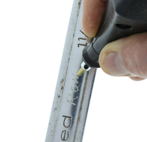 Close-up of Electric Engraver With Carbide Tipped Point, 120V 60Hz, 7200 SPM engraving metal surface, showing precise markings