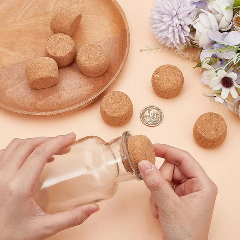 Person placing 8 Pack Wooden Cork Stoppers for Wide Mouth Bottles 1 to 2 Inch Opening on glass bottle, with wooden lid detail.