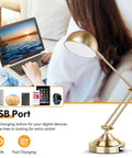 Brass Vintage Desk Lamp with USB Port next to a person using a laptop, illustrating fast charging feature and adjustable arm.
