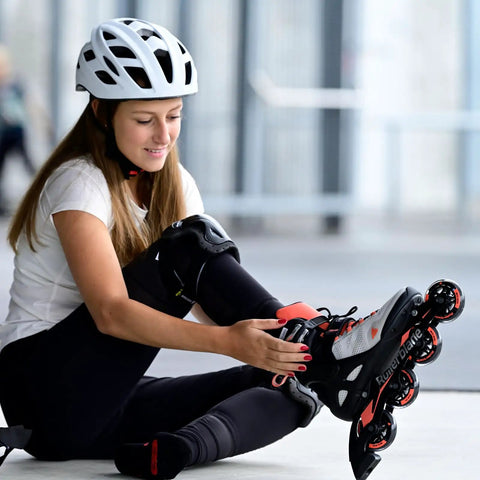 Woman wearing white helmet adjusting Macroblade 80 Women's Fitness Inline Skates For Casual Training with Secure Cuff Support.