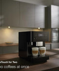 Sleek Fully Automatic Coffee And Espresso Machine With Silent Steel Grinding Chamber For Killer Cup Creations And Rich Silky Milk Foam For Serious Home Baristas brewing two coffees simultaneously in a modern kitchen.
