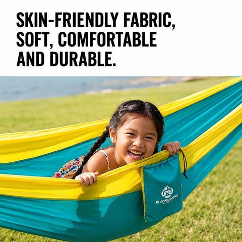 Child smiling in Ultra Lightweight Camping Hammock With 500 Lb Capacity And Tree Straps for travel, bright yellow and teal.