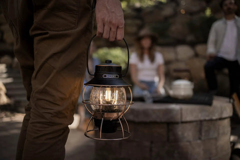 Antique Bronze LED Camping Lantern With Rechargeable Battery And USB Power Vintage Inspired Outdoor Light in use by a campfire