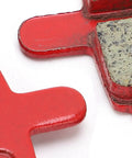 Close-up of Eight Pack SemiMetallic Disc Brake Pads for Mountain and Electric Bikes, showing red backing and pad material.