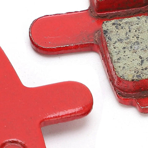 Close-up of Eight Pack SemiMetallic Disc Brake Pads for Mountain and Electric Bikes, showing red backing and pad material.