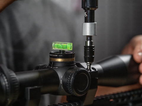 Pro Grade Dual Bubble Scope Leveling Kit For Foolproof Reticle Alignment One Handed Elevation Drop Adjustment Rifle Optics Zeroing Fixture mounted on a rifle scope.
