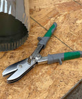 Five Blade Sheet Metal Crimping Tool With Soft Grip Handles And Safety Lock next to ductwork on wooden surface